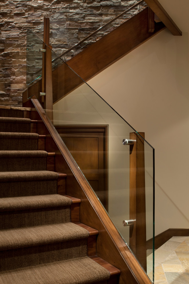Trendy wooden glass railing staircase photo in Denver with wooden risers