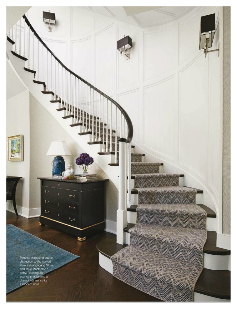 Large traditional wood curved staircase in Chicago with painted wood risers and feature lighting.