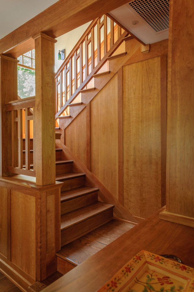 На фото: п-образная деревянная лестница среднего размера в стиле кантри с деревянными ступенями и деревянными перилами с