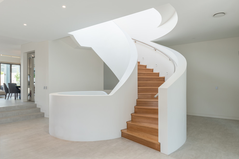 Diseño de escalera curva contemporánea grande con escalones de madera y contrahuellas de madera