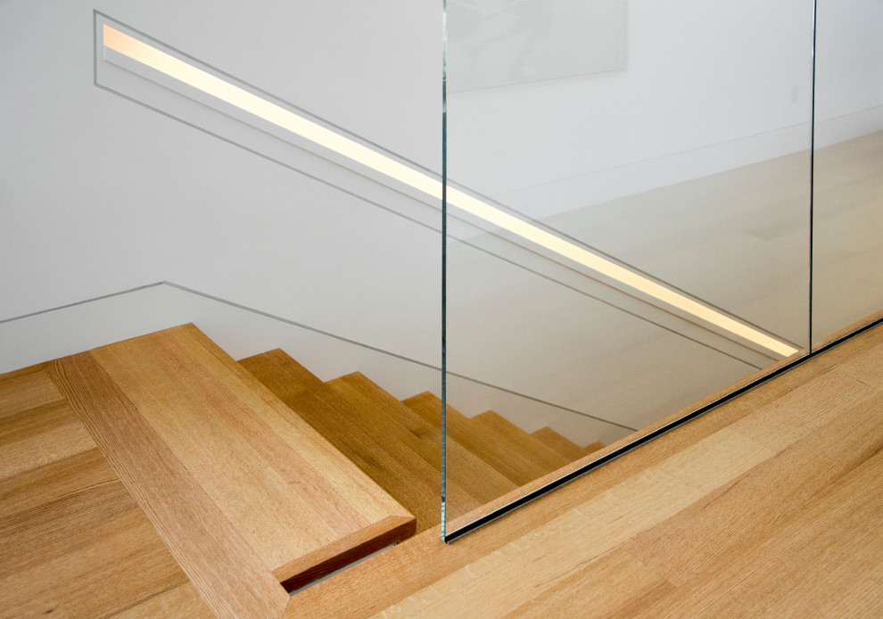 Идея дизайна: прямая лестница в стиле модернизм с деревянными ступенями и стеклянными подступенками