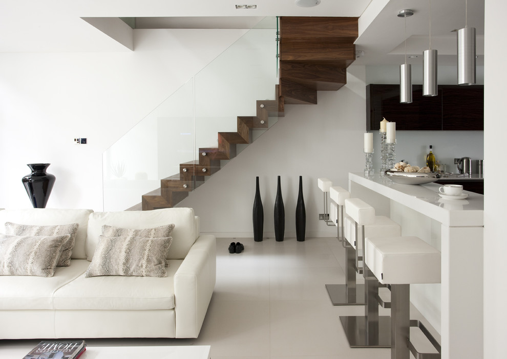 Minimalist wooden floating glass railing staircase photo in London with wooden risers