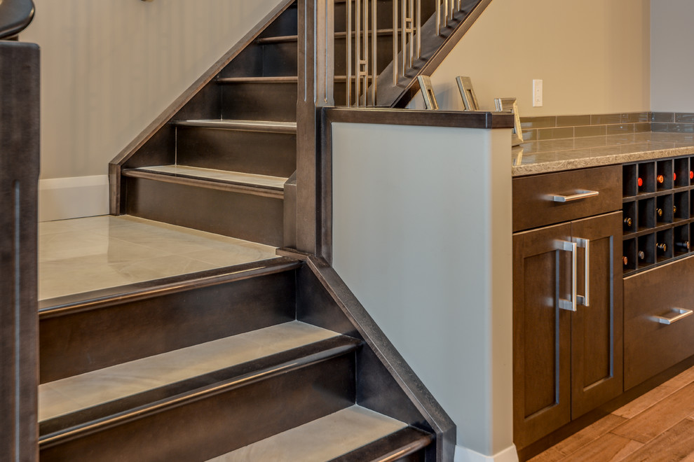 Foto de escalera en L clásica renovada de tamaño medio con escalones con baldosas y contrahuellas de madera