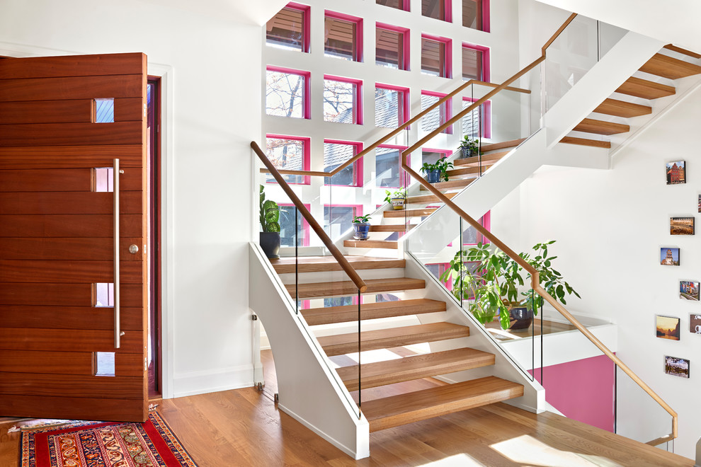 Cette photo montre un escalier sans contremarche tendance en L avec des marches en bois, un garde-corps en matériaux mixtes et palier.