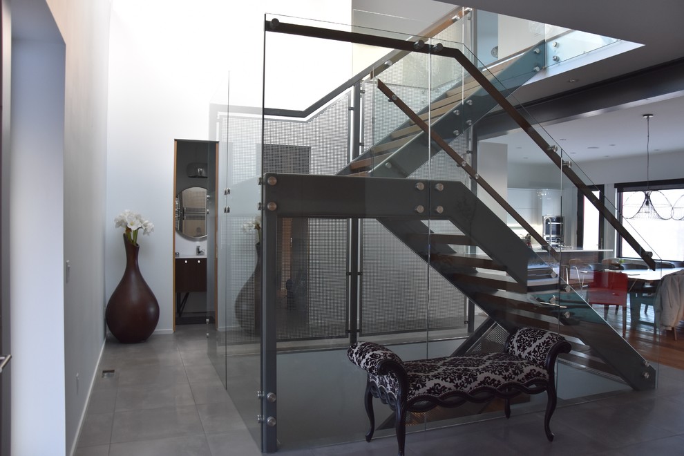 Large minimalist wooden u-shaped open and glass railing staircase photo in Edmonton