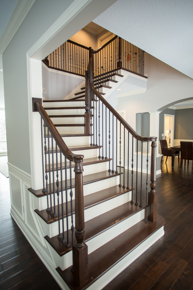 Свежая идея для дизайна: большая угловая лестница в классическом стиле с деревянными ступенями, крашенными деревянными подступенками и перилами из смешанных материалов - отличное фото интерьера