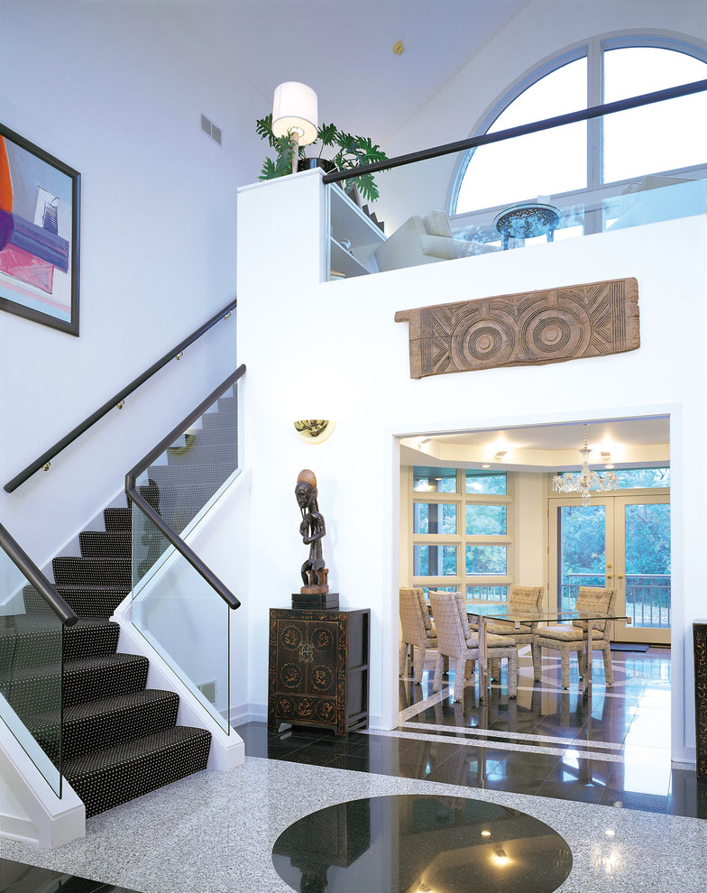 На фото: угловая лестница в современном стиле с ступенями с ковровым покрытием, ковровыми подступенками и стеклянными перилами с