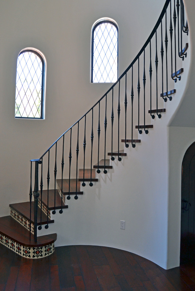Cette photo montre un escalier courbe chic avec des marches en bois et des contremarches carrelées.