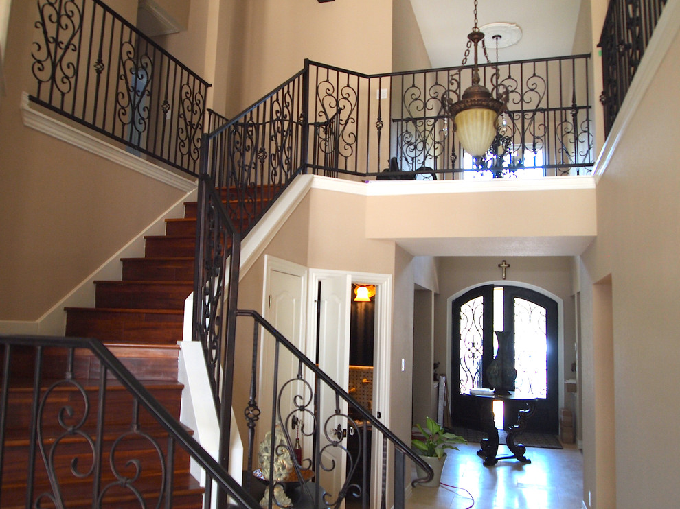 Inspiration for a large timeless wooden curved metal railing staircase remodel in Austin with wooden risers