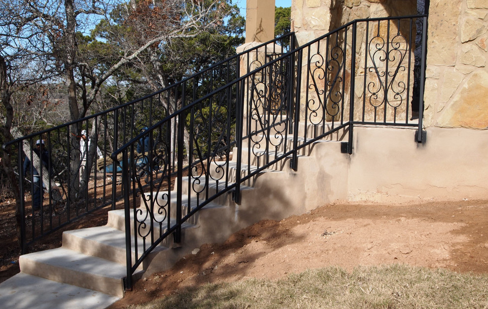 Imagen de escalera curva tradicional de tamaño medio con escalones de hormigón, contrahuellas de metal y barandilla de metal