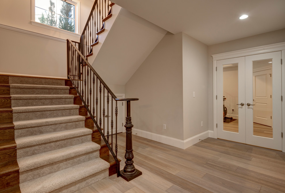 На фото: угловая лестница среднего размера в стиле ретро с ступенями с ковровым покрытием, крашенными деревянными подступенками и деревянными перилами