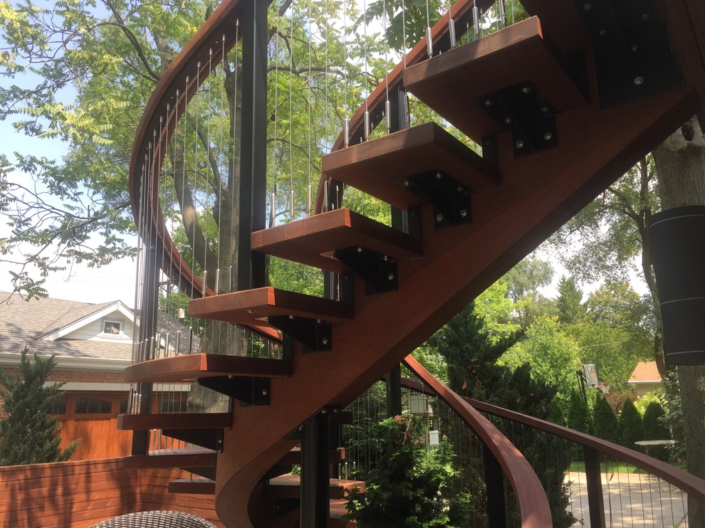 Idée de décoration pour un escalier sans contremarche hélicoïdal design de taille moyenne avec des marches en bois et un garde-corps en bois.