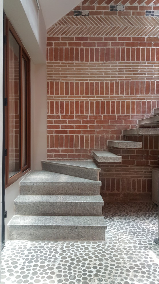Réalisation d'un escalier courbe design en béton avec des contremarches en béton.
