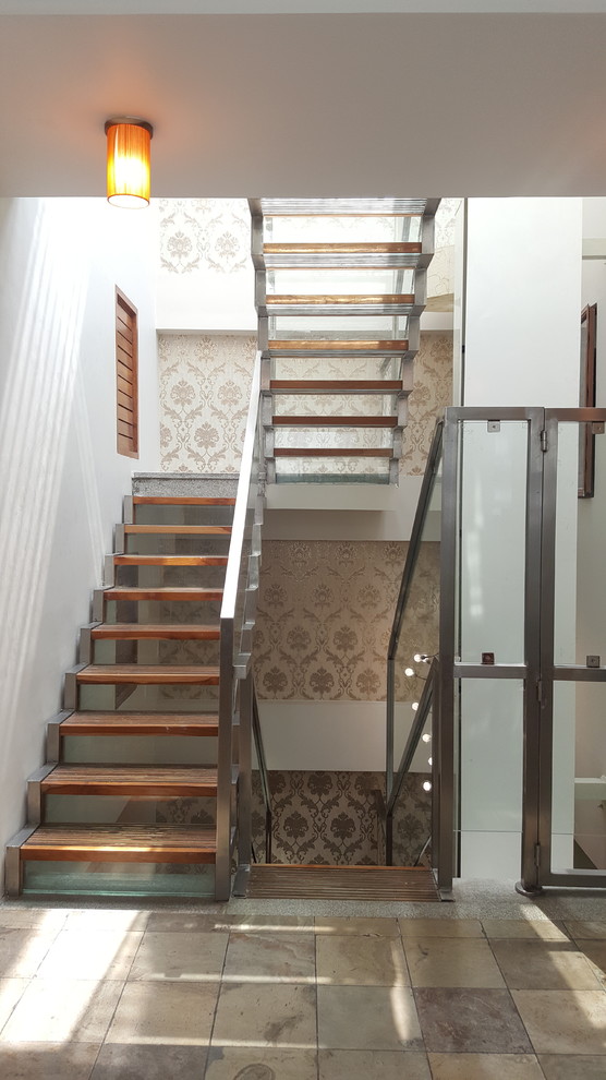 Exemple d'un escalier chic en U avec des marches en bois, des contremarches en verre et un garde-corps en métal.