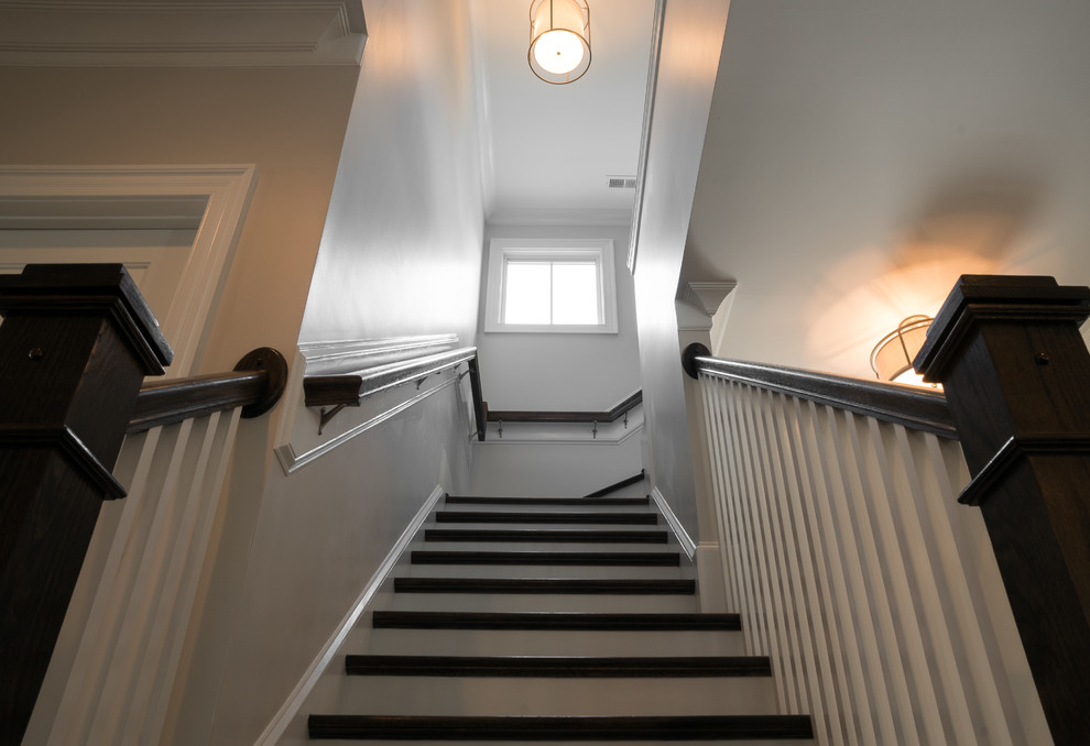 Idées déco pour un escalier craftsman en L de taille moyenne avec des marches en bois, un garde-corps en bois et éclairage.