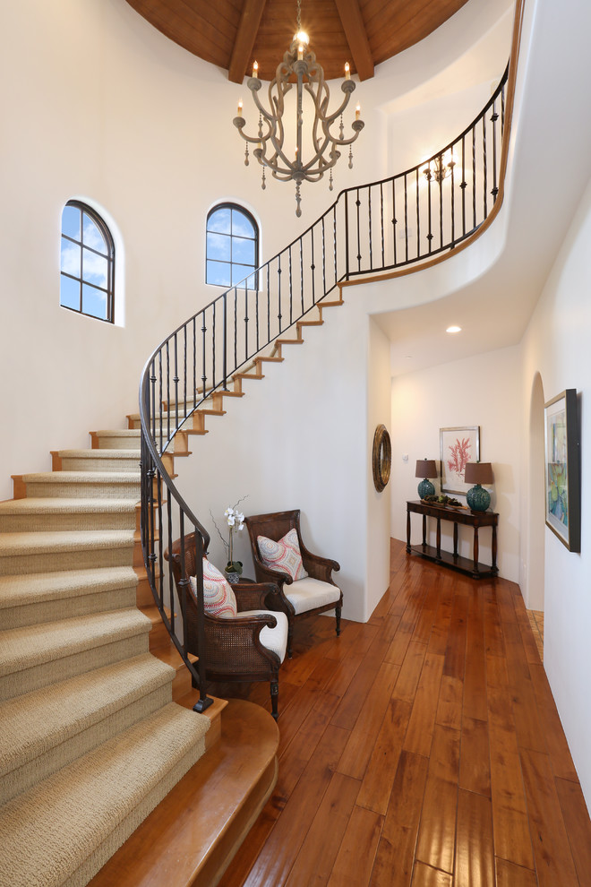 Mediterranean wood curved staircase in Orange County with wood risers.
