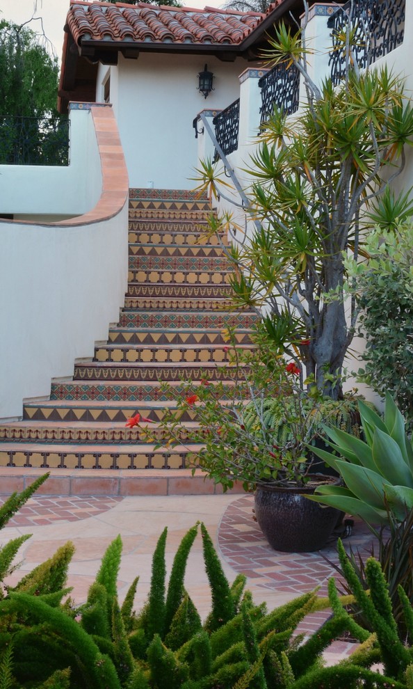 На фото: огромная лестница в средиземноморском стиле с ступенями из плитки и подступенками из плитки с