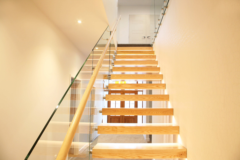Cette image montre un escalier sans contremarche flottant design avec des marches en bois.