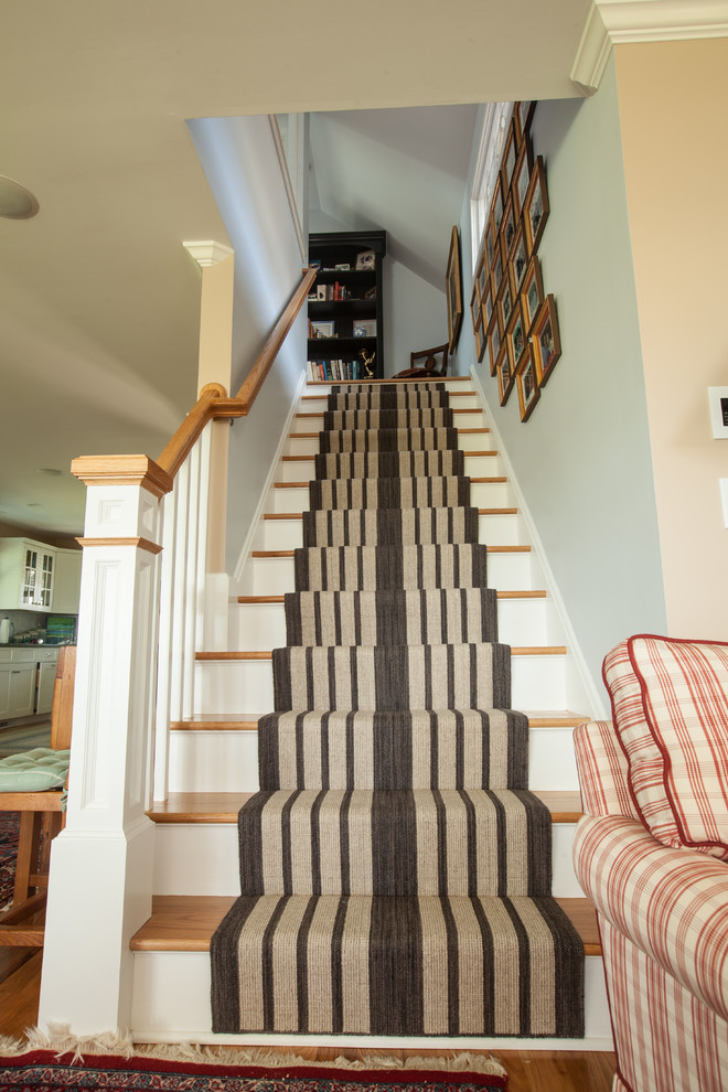 Inspiration for a mid-sized transitional carpeted straight staircase remodel in Bridgeport with wooden risers