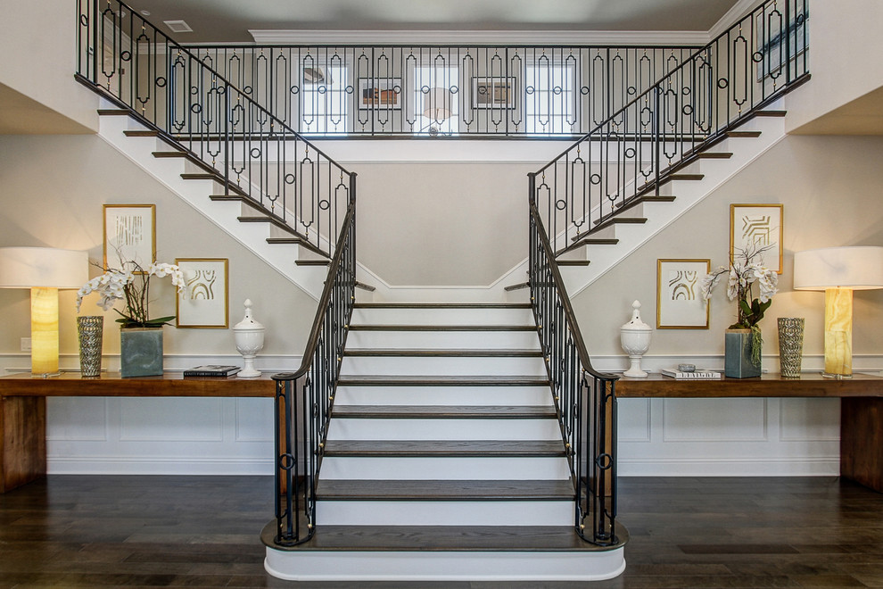 Стильный дизайн: лестница в классическом стиле с деревянными ступенями, крашенными деревянными подступенками и металлическими перилами - последний тренд