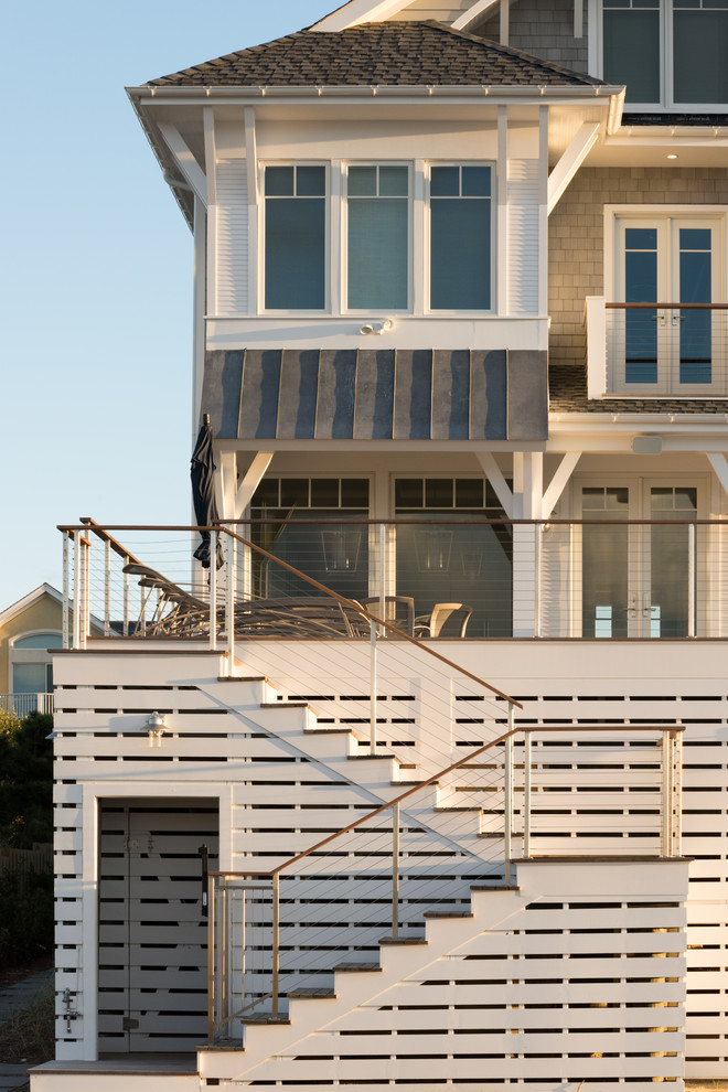 На фото: п-образная деревянная лестница среднего размера в морском стиле с деревянными ступенями и перилами из тросов