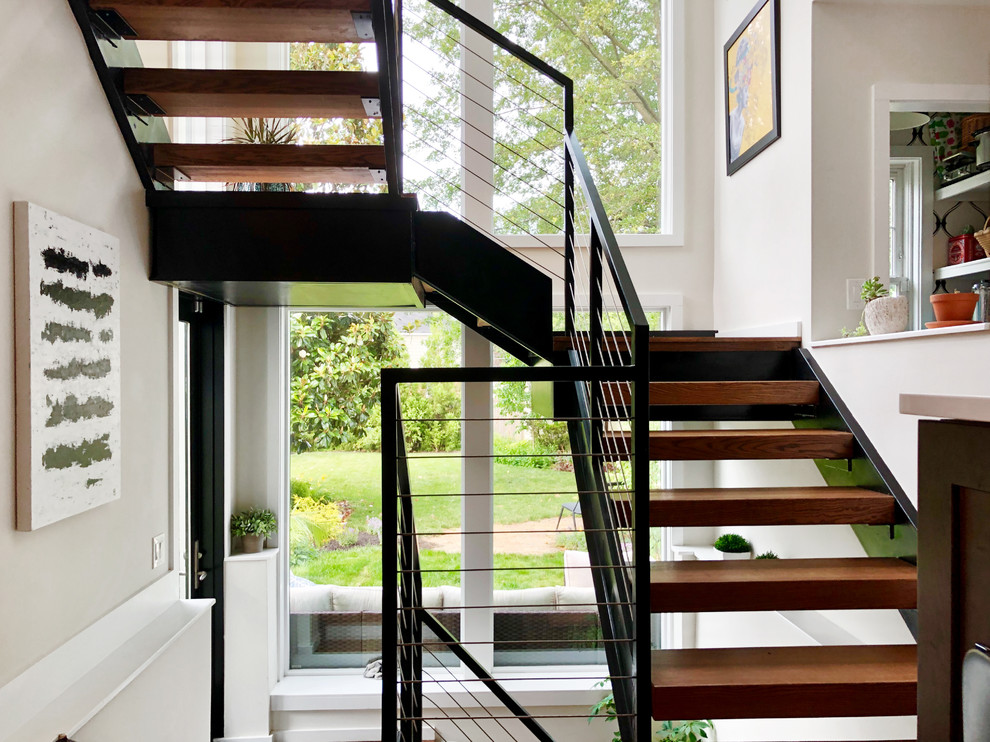 Idées déco pour un grand escalier sans contremarche hélicoïdal classique avec des marches en bois et un garde-corps en métal.