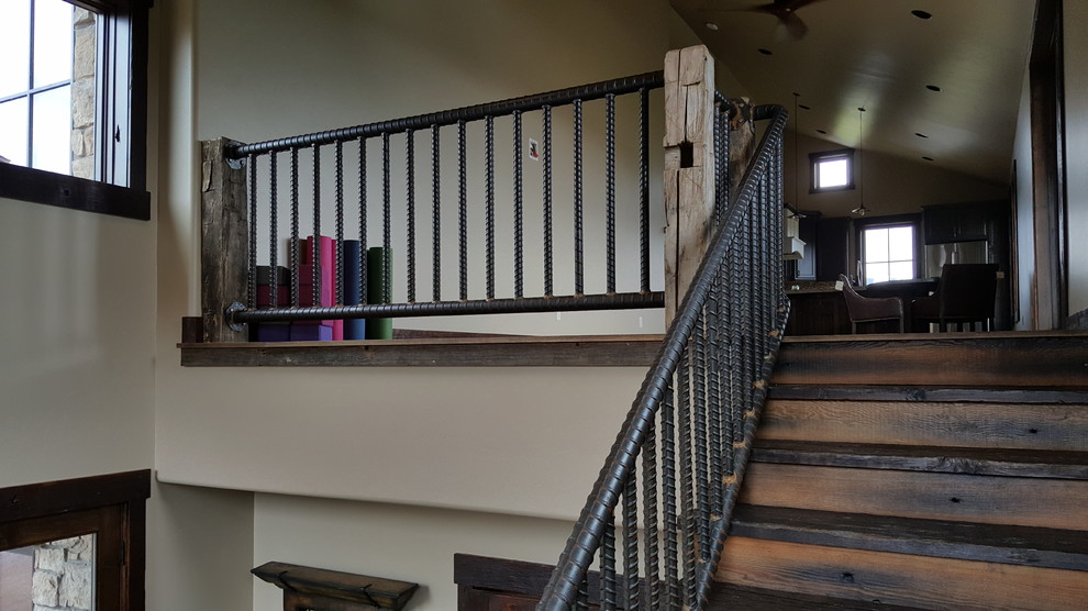 他の地域にある広いインダストリアルスタイルのおしゃれなかね折れ階段 (木の蹴込み板、金属の手すり) の写真