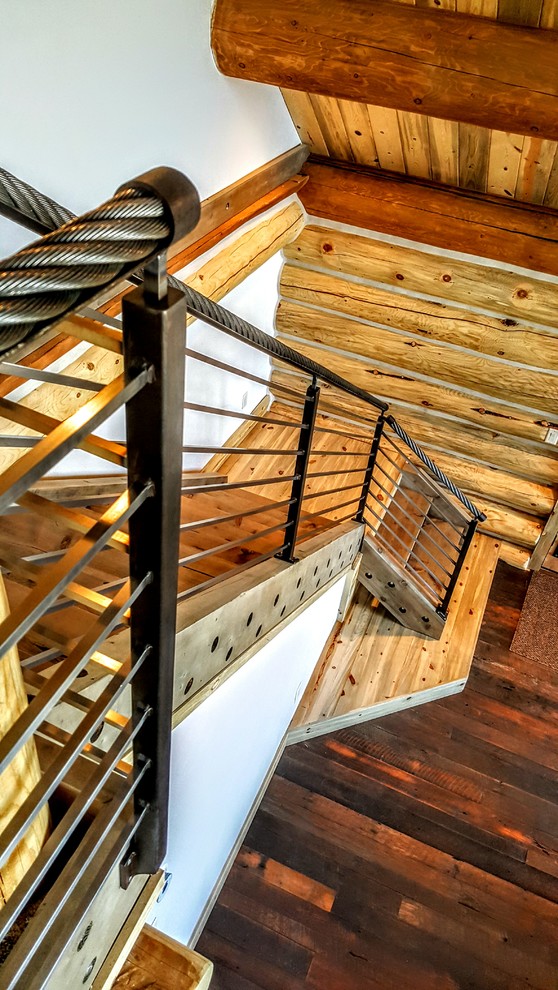 Inredning av en amerikansk liten l-trappa i trä, med räcke i metall och öppna sättsteg
