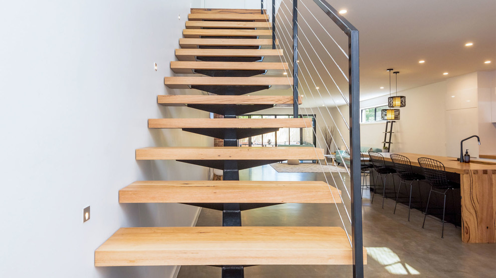 Foto de escalera contemporánea sin contrahuella con escalones de madera y barandilla de metal