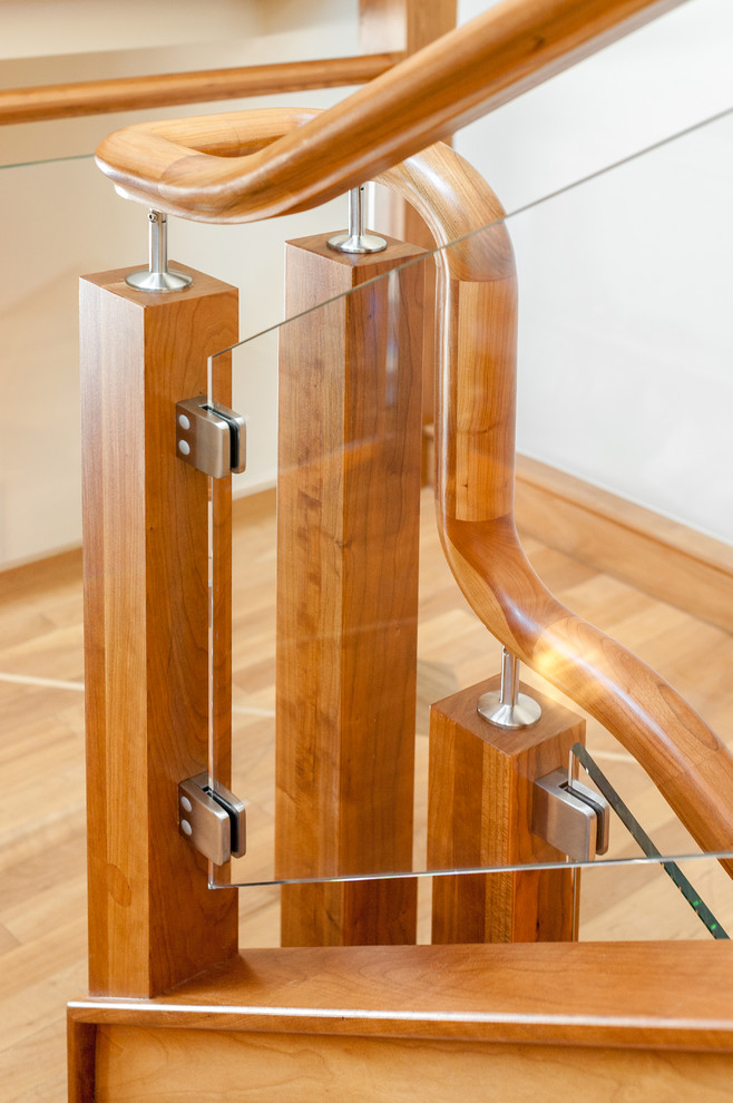 Diseño de escalera en U actual grande con escalones de madera, contrahuellas de madera y barandilla de madera