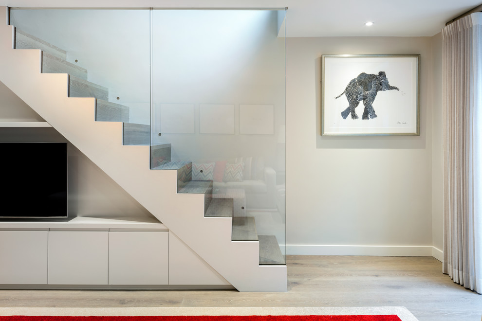 Inspiration for a mid-sized contemporary wooden straight glass railing staircase remodel in London with wooden risers