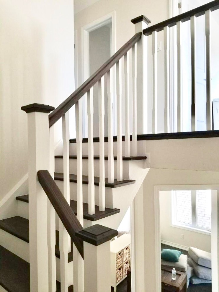 Idées déco pour un escalier peint classique en L de taille moyenne avec des marches en bois et un garde-corps en bois.