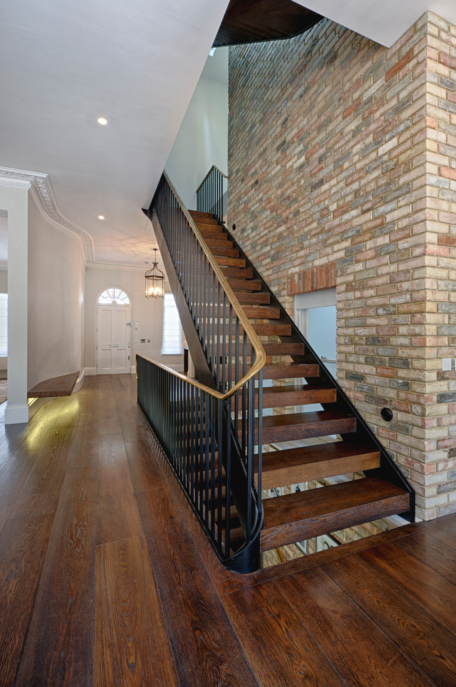 Example of a transitional wooden open staircase design in Surrey
