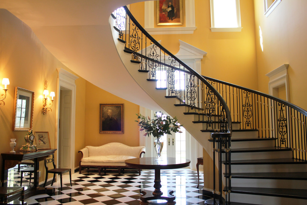 Elegant wooden curved staircase photo in Indianapolis with painted risers
