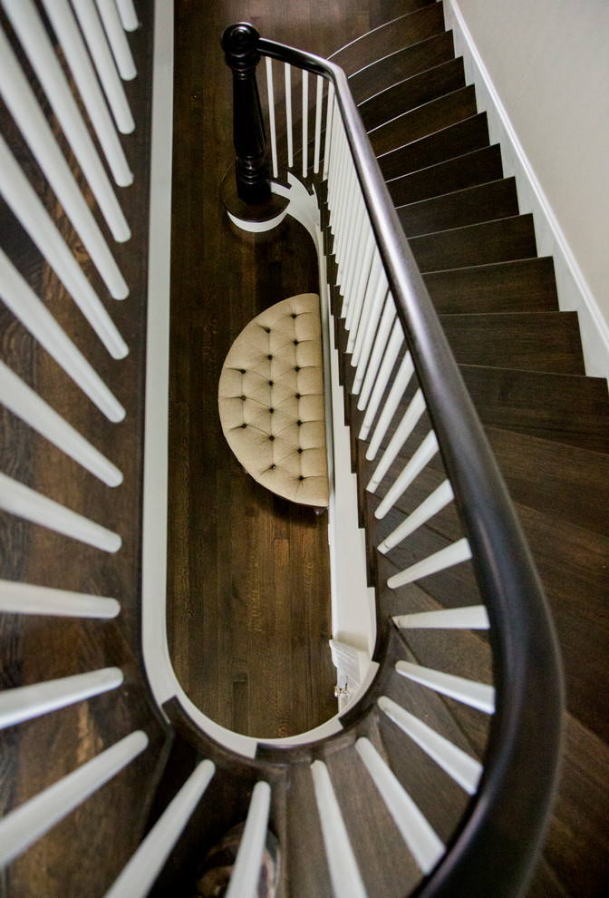 Modelo de escalera curva tradicional grande con escalones de madera y contrahuellas de madera pintada