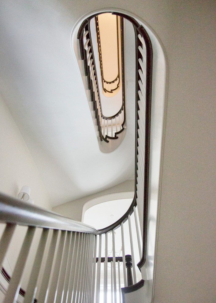Photo of a large traditional wood curved staircase in Boston with wood risers.