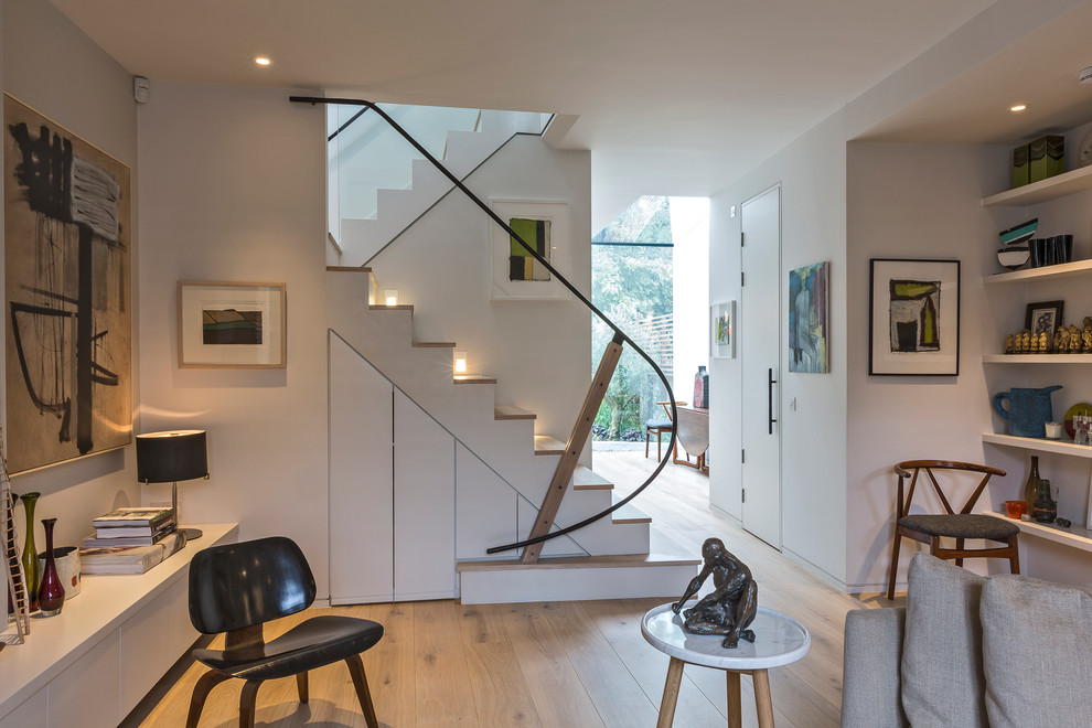 На фото: п-образная лестница в современном стиле с деревянными ступенями и кладовкой или шкафом под ней с