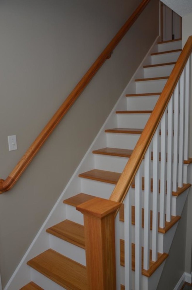 Idée de décoration pour un escalier peint droit tradition de taille moyenne avec des marches en bois et un garde-corps en bois.
