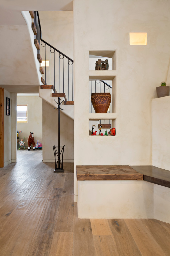 Imagen de escalera suspendida de estilo americano de tamaño medio con escalones de madera, contrahuellas de madera pintada y barandilla de metal