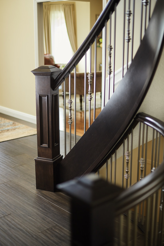 Пример оригинального дизайна: изогнутая деревянная лестница в классическом стиле с деревянными ступенями и деревянными перилами