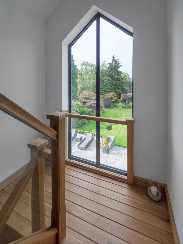 Mid-sized minimalist wooden u-shaped wood railing staircase photo in West Midlands with wooden risers