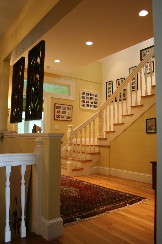 Elegant wooden l-shaped staircase photo in Boston with painted risers