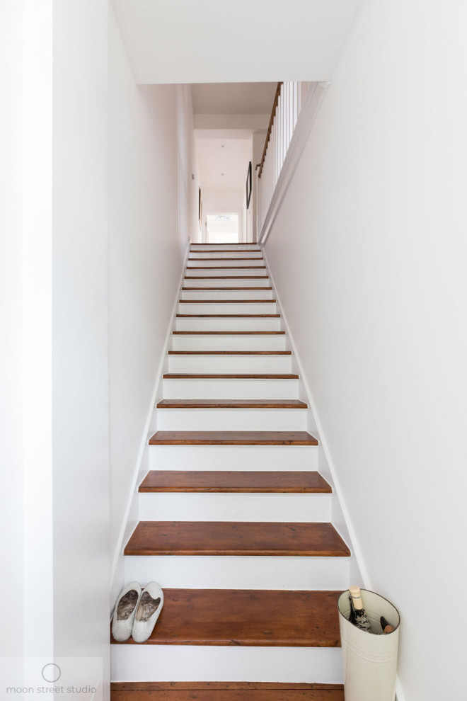 Exemple d'un escalier peint droit tendance de taille moyenne avec des marches en bois et un garde-corps en bois.
