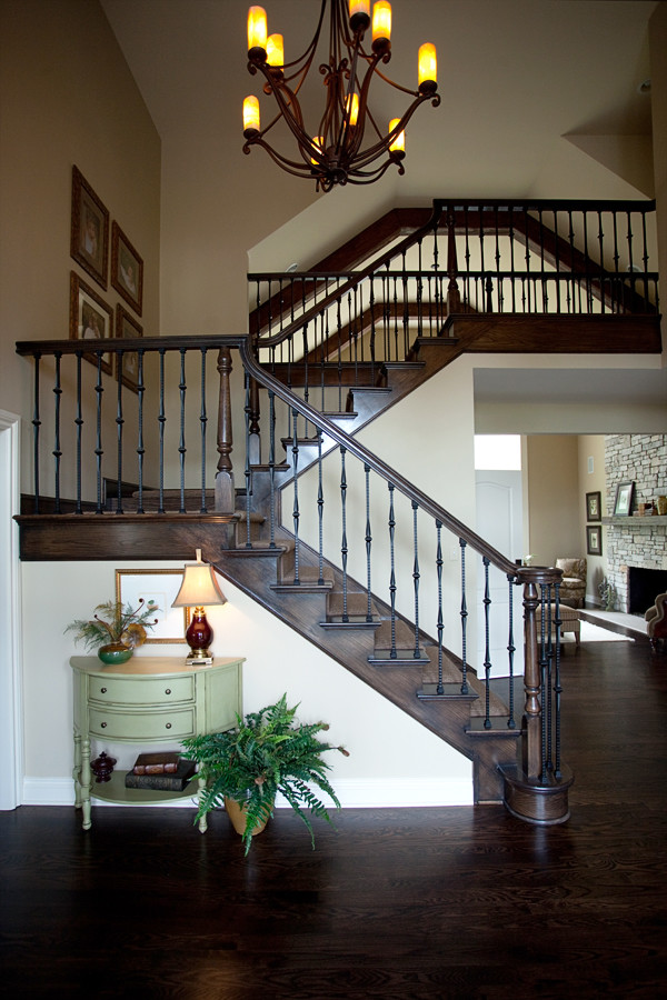 Photo of an expansive traditional carpeted staircase in Detroit with wood risers and feature lighting.