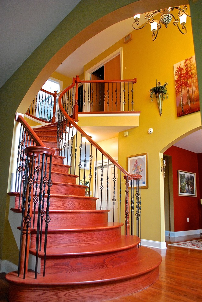 Exemple d'un grand escalier courbe chic avec des marches en bois et des contremarches en bois.