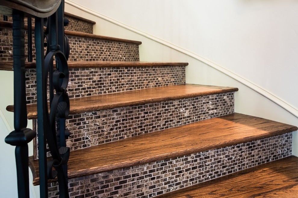 Mid-sized tuscan wooden curved metal railing staircase photo in Dallas with tile risers
