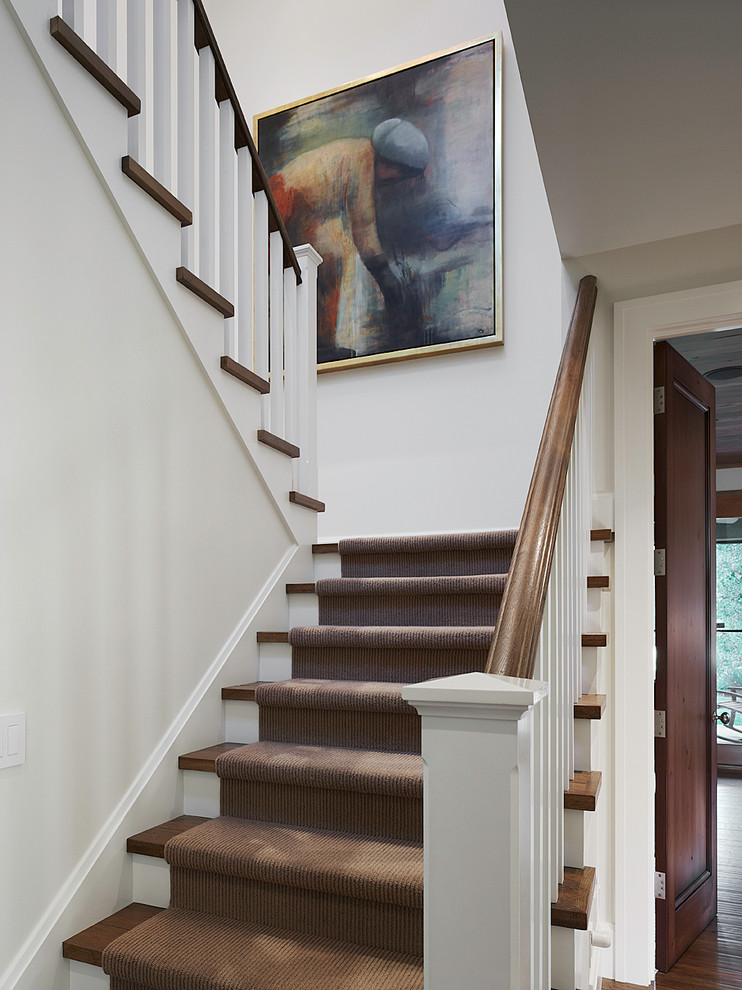 This is an example of a classic wood u-shaped staircase in San Francisco with painted wood risers.