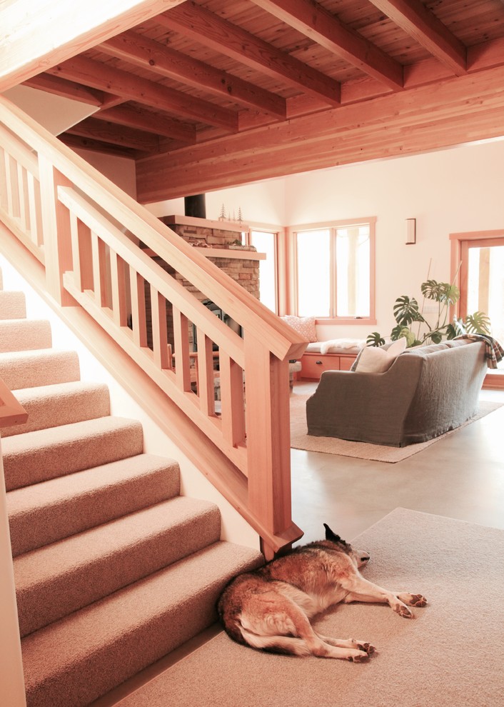 Imagen de escalera recta rústica de tamaño medio con escalones enmoquetados, contrahuellas enmoquetadas y barandilla de madera