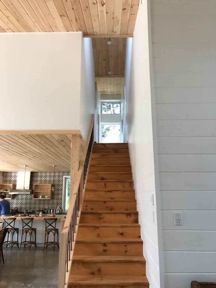 Exemple d'un grand escalier droit tendance avec des marches en bois, des contremarches en bois et un garde-corps en matériaux mixtes.