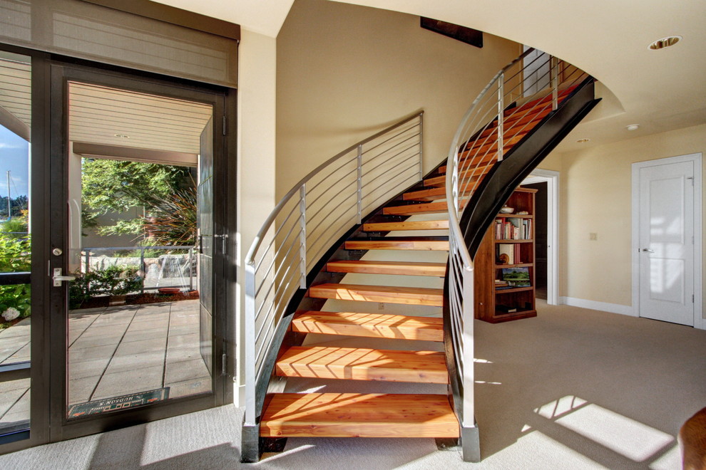 Aménagement d'un grand escalier sans contremarche courbe moderne avec des marches en bois.
